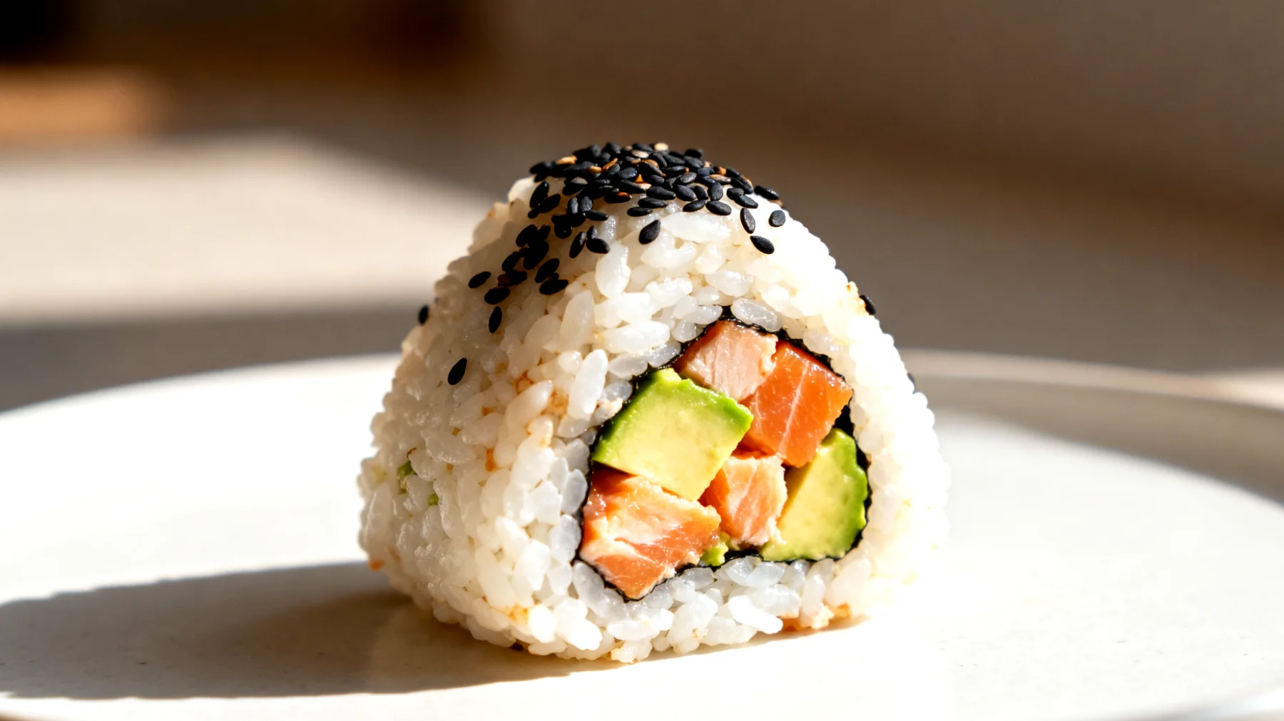 Onigiri con salmone, avocado e semi di sesamo"