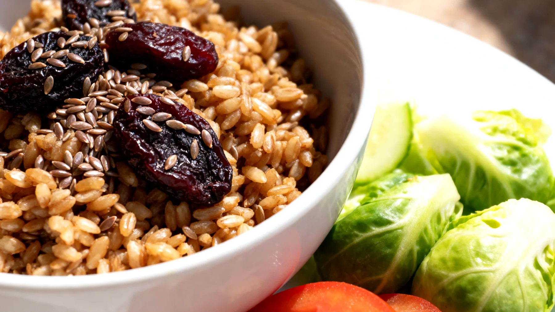 Insalata di farro con prugne secche, semi di lino e verdure crude"